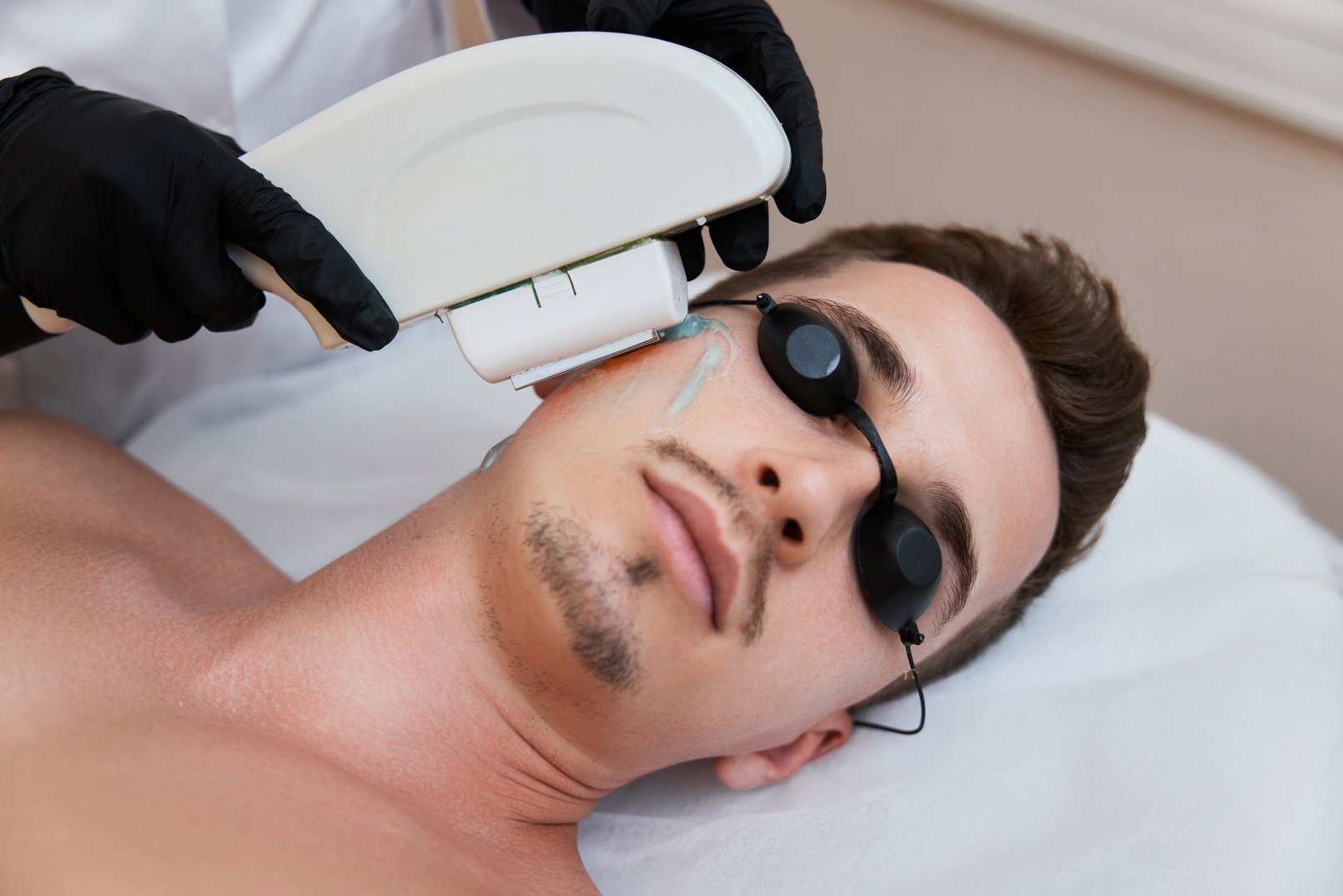 Young Man Receiving Epilation in Beauty Center. Laser Hair Removal Procedure